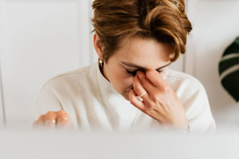 Mujer frotándose los ojos por cansancio y fatiga visual