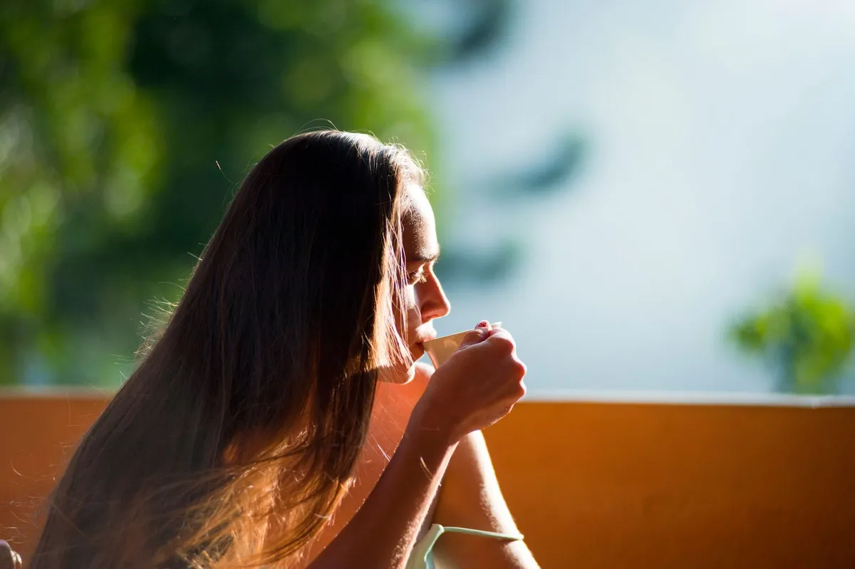 Mujer disfrutando de la luz natural del sol al aire libre por la mañana