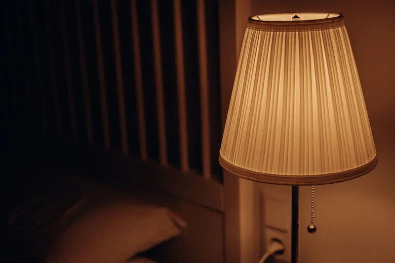 Lamparita de mesilla con luz cálida en un dormitorio acogedor