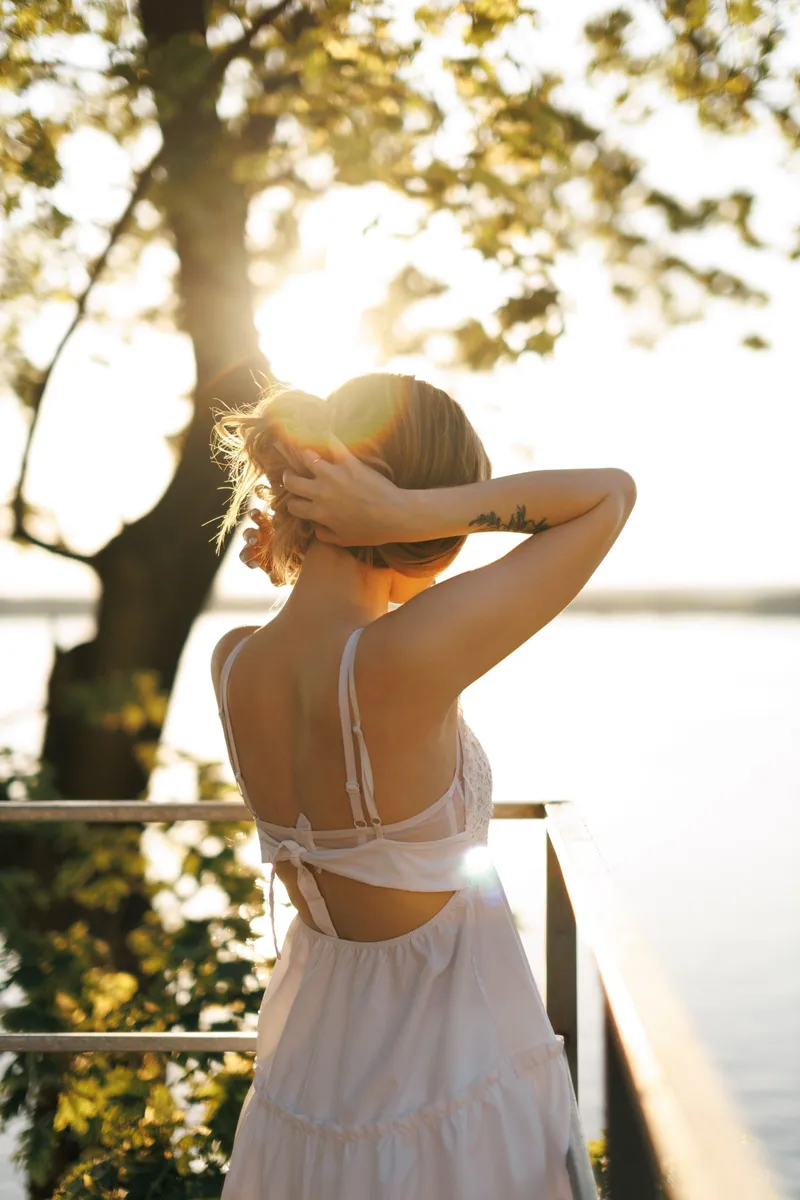 Mujer al aire libre bajo la luz natural junto a un lago