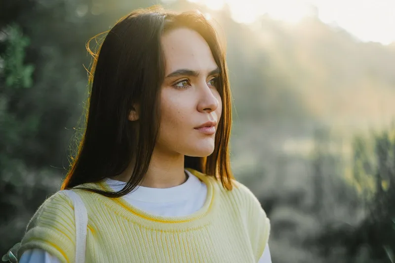 Joven al aire libre bajo la luz natural del sol en un parque